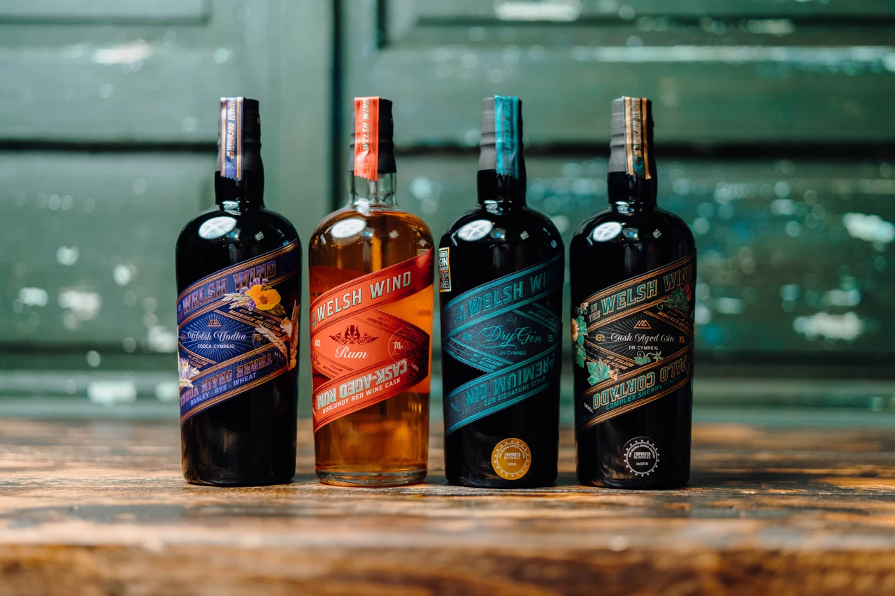 In the Welsh Wind gin and rum bottles arranged on a wooden surface.
